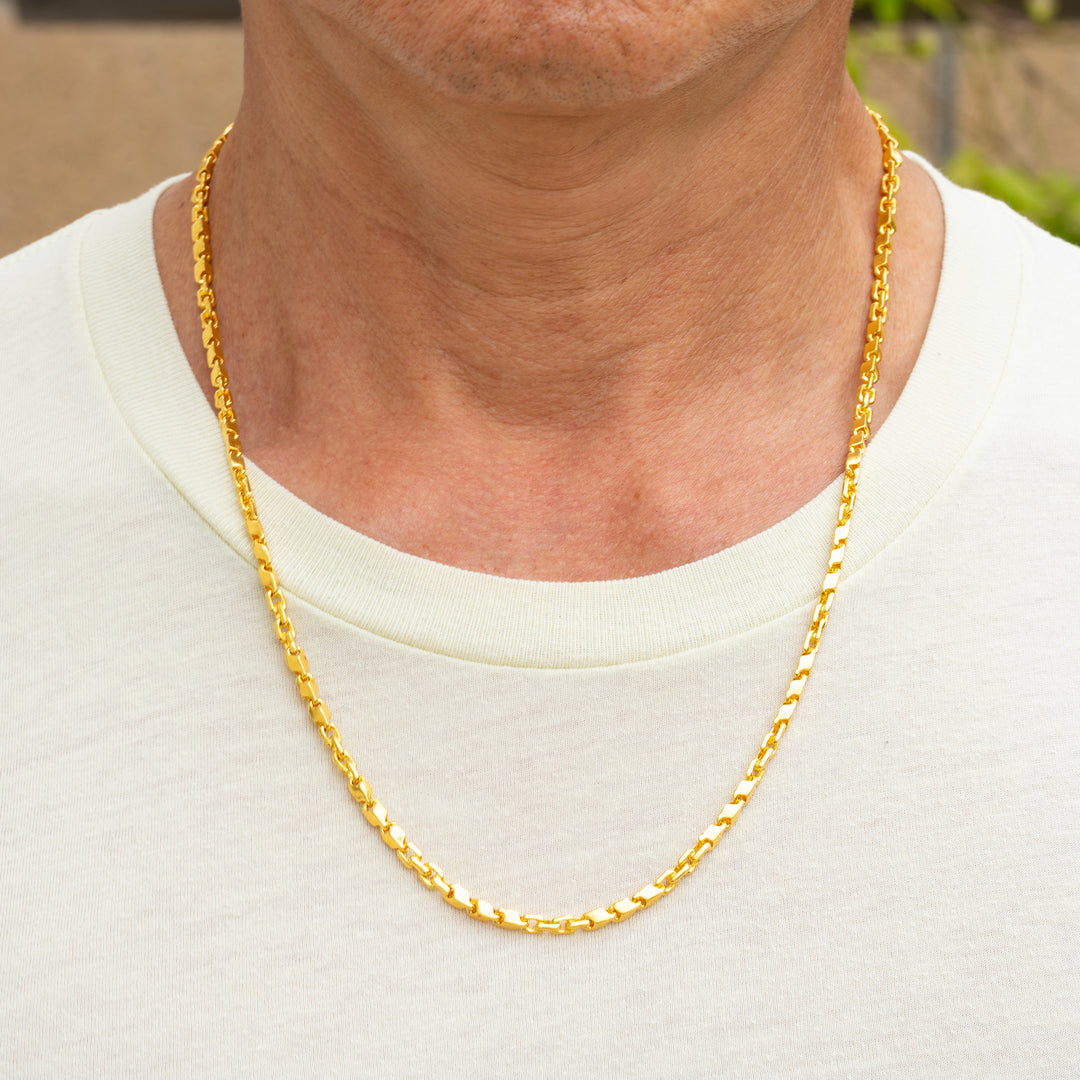 Man wearing 24k gold fancy link chain necklace, 4mm width, showing elegant drape
