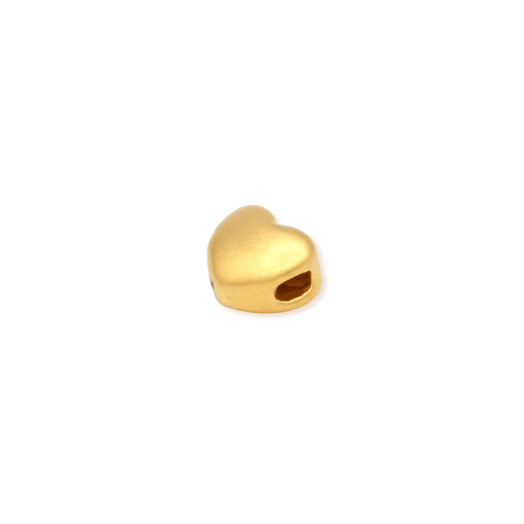 Side view of a 24k Gold heart-shaped charm on a white background